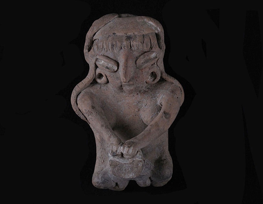 Female Human Figurine Kneeling to Grind Maize in Metate (front). Crafted to be three dimensional, this figurine is fully modeled front and rear. Buff earthenware, unpolished, traces of white paint.