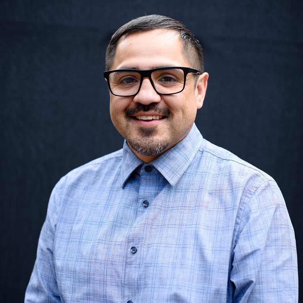 The artist in a blue shirt and glasses.