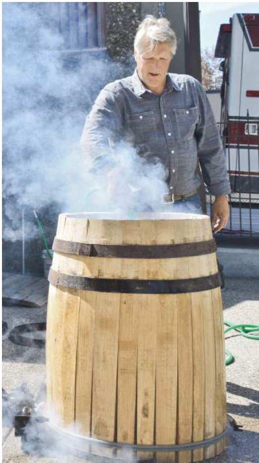 Rick DeFerrari prepares a wine barrel with smoke