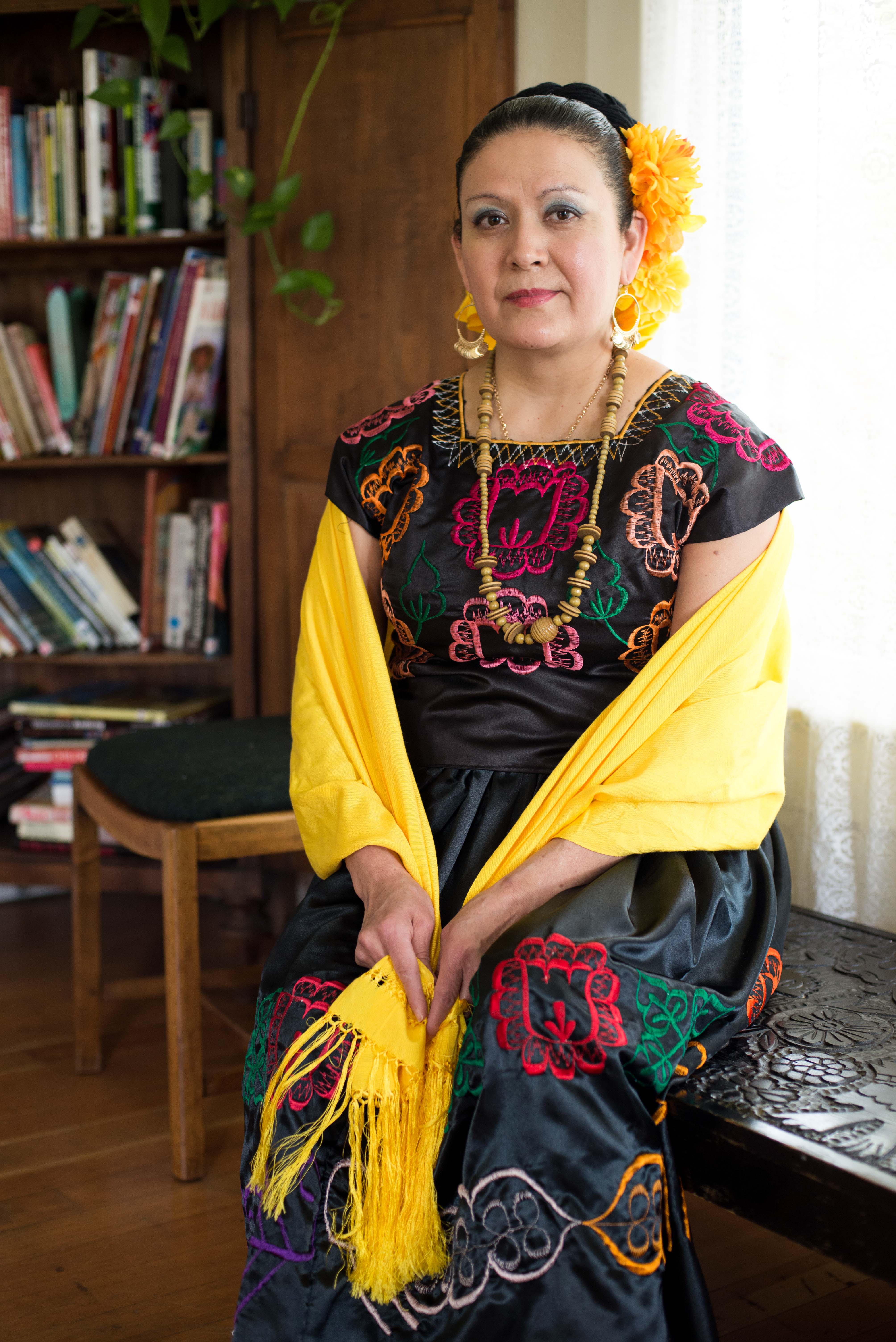 Maria Laguna sitting in a chair wearing her traditional dancing costume