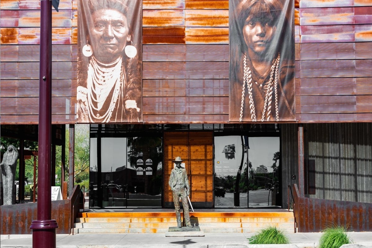 Front of a Museum featuring Indigenous portraits and a cowboy statue