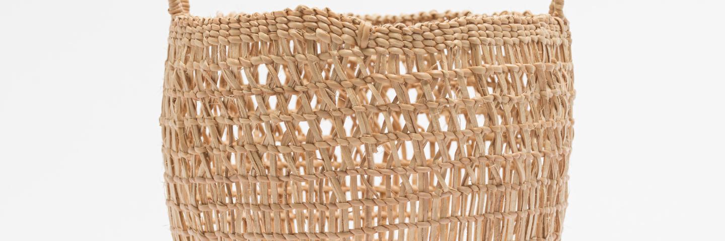 a woven basket with two handles against a white background