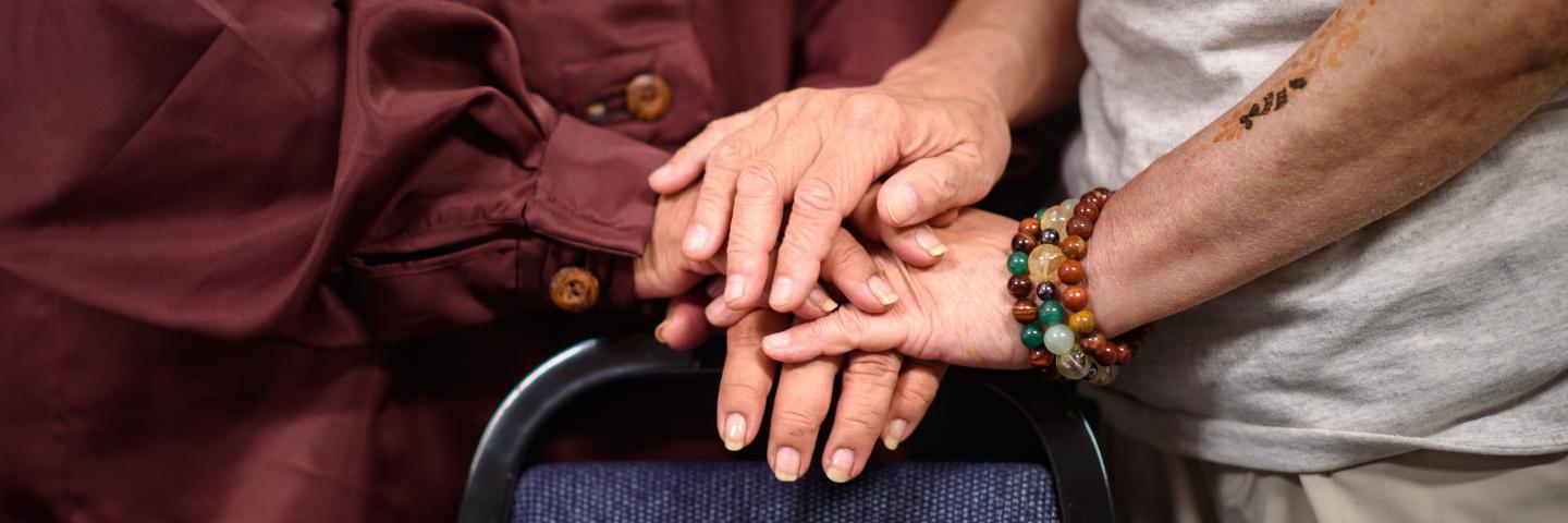 Two hands clasped on the back of a blue chair