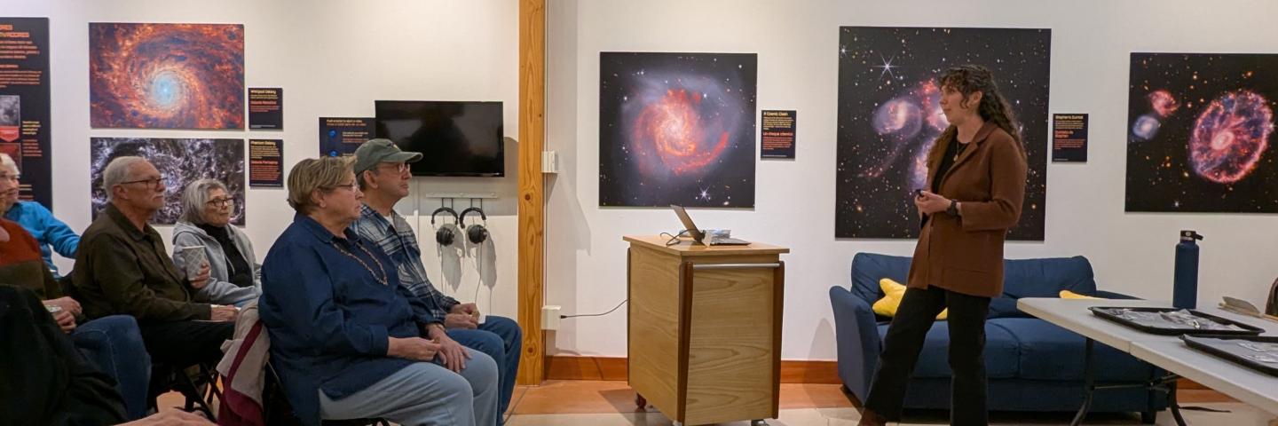 A small group of people listen to Katelyn McDonough speak