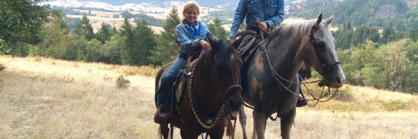 Young girl and father on horseback