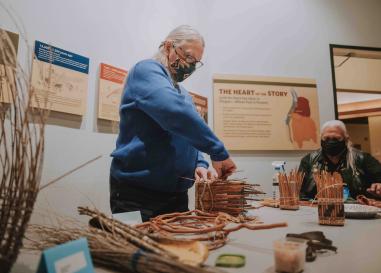 Brenda Brainard, an Indigenous woman, makes a basket