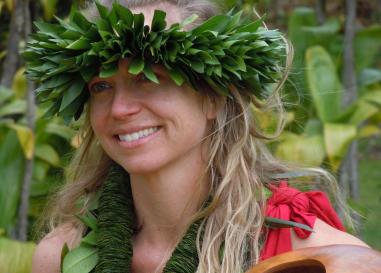 A white woman with a haku headband and lei around her neck.
