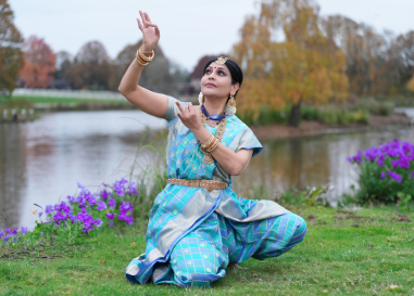 Jayanthi dances in front of a pond.
