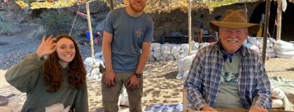 Three people with screens working at a field school site