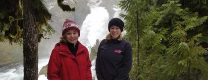 Two MNCH Ambassadors in front of a waterfall on snowshoeing trip.