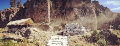 Rock formation with sand bags and shade shelter set up.
