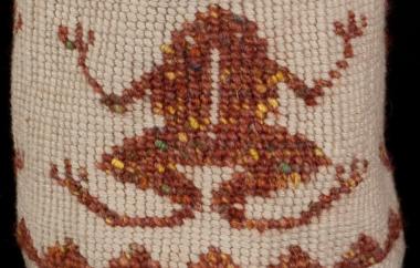 Detail of woven frog on cylindrical bag