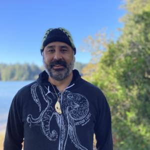 Shirod Younker stands in front of a river.