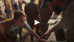 Screenshot of a video featuring a student archaeologist