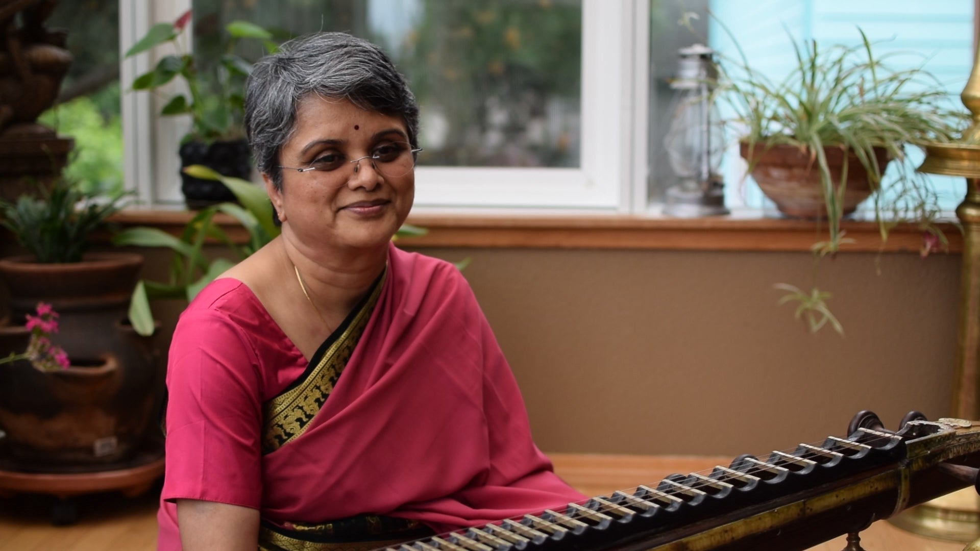 indian woman sitting in front of a musical instrument