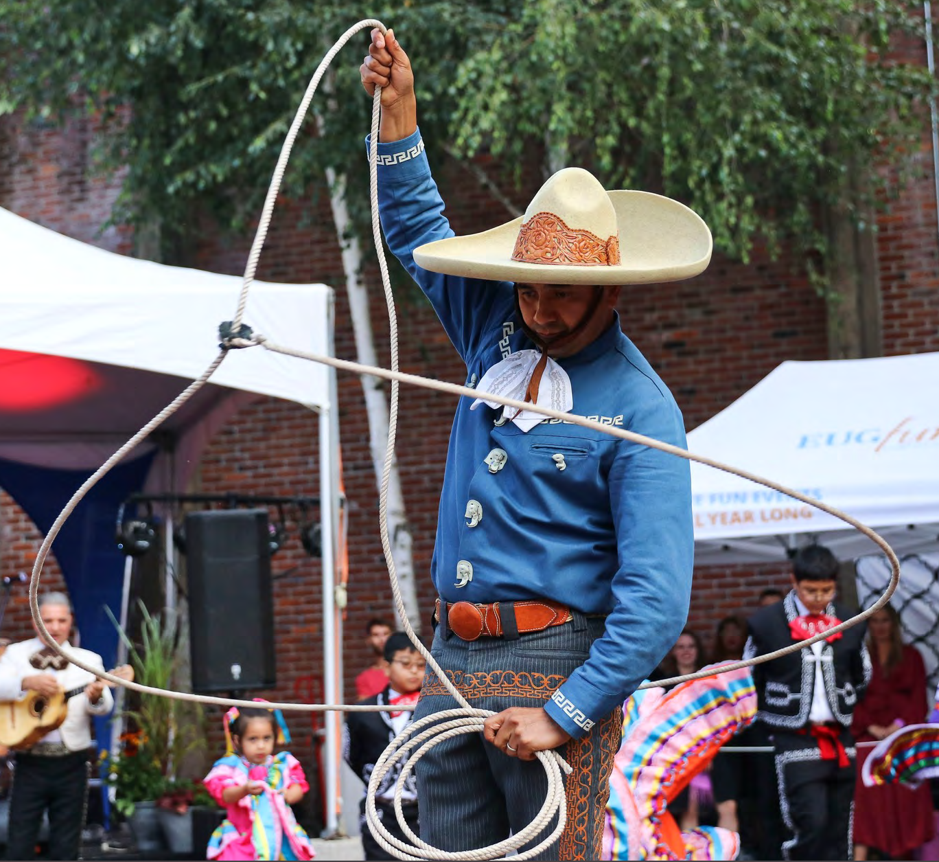 mexican man in a blue shirt performing charreria rope works