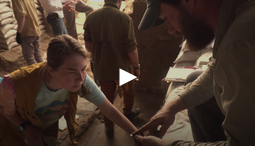 Screenshot of a video featuring a student archaeologist