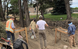 Four archaeologists work at a dig