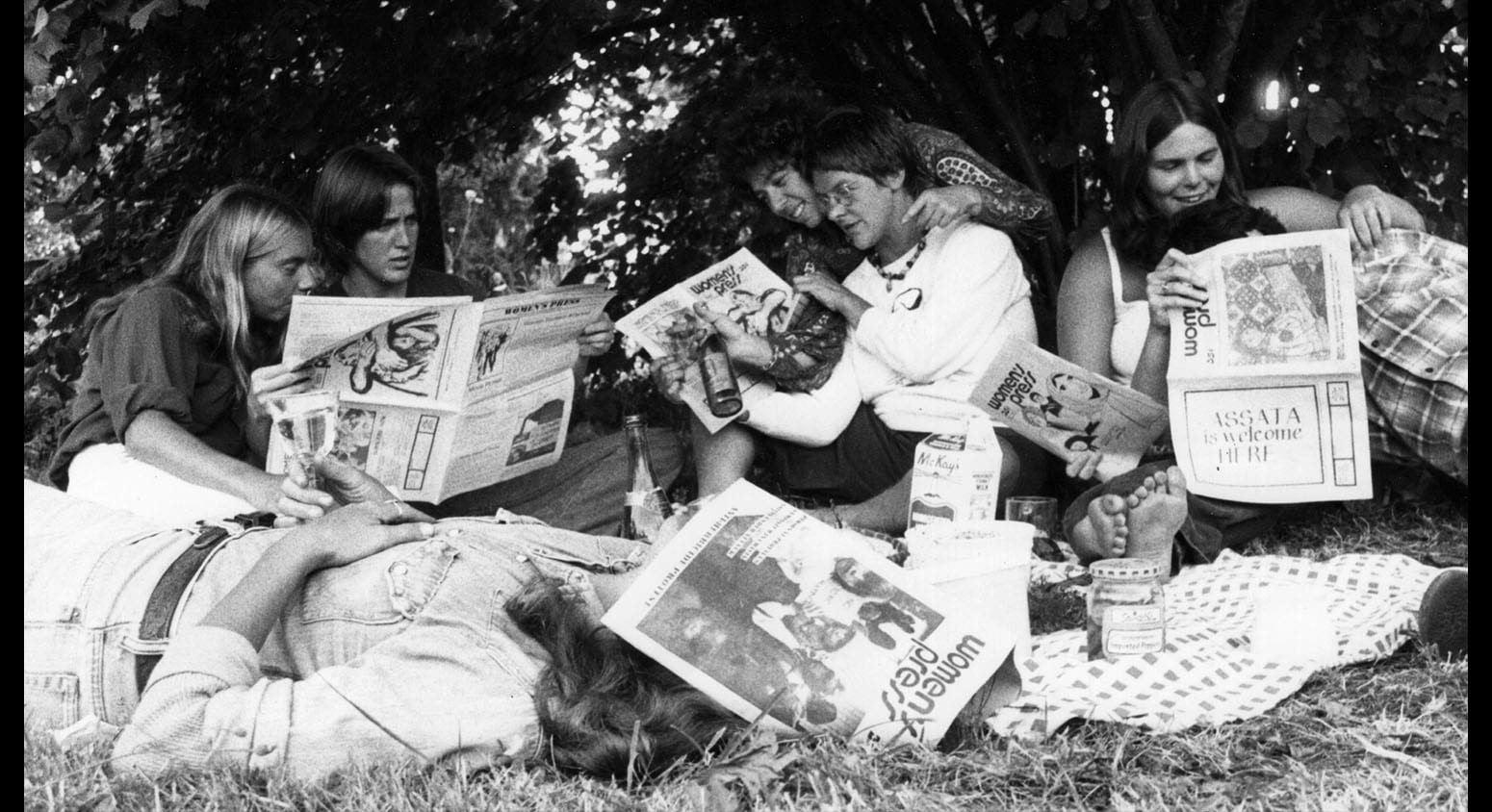 Several women reading copies of women's press