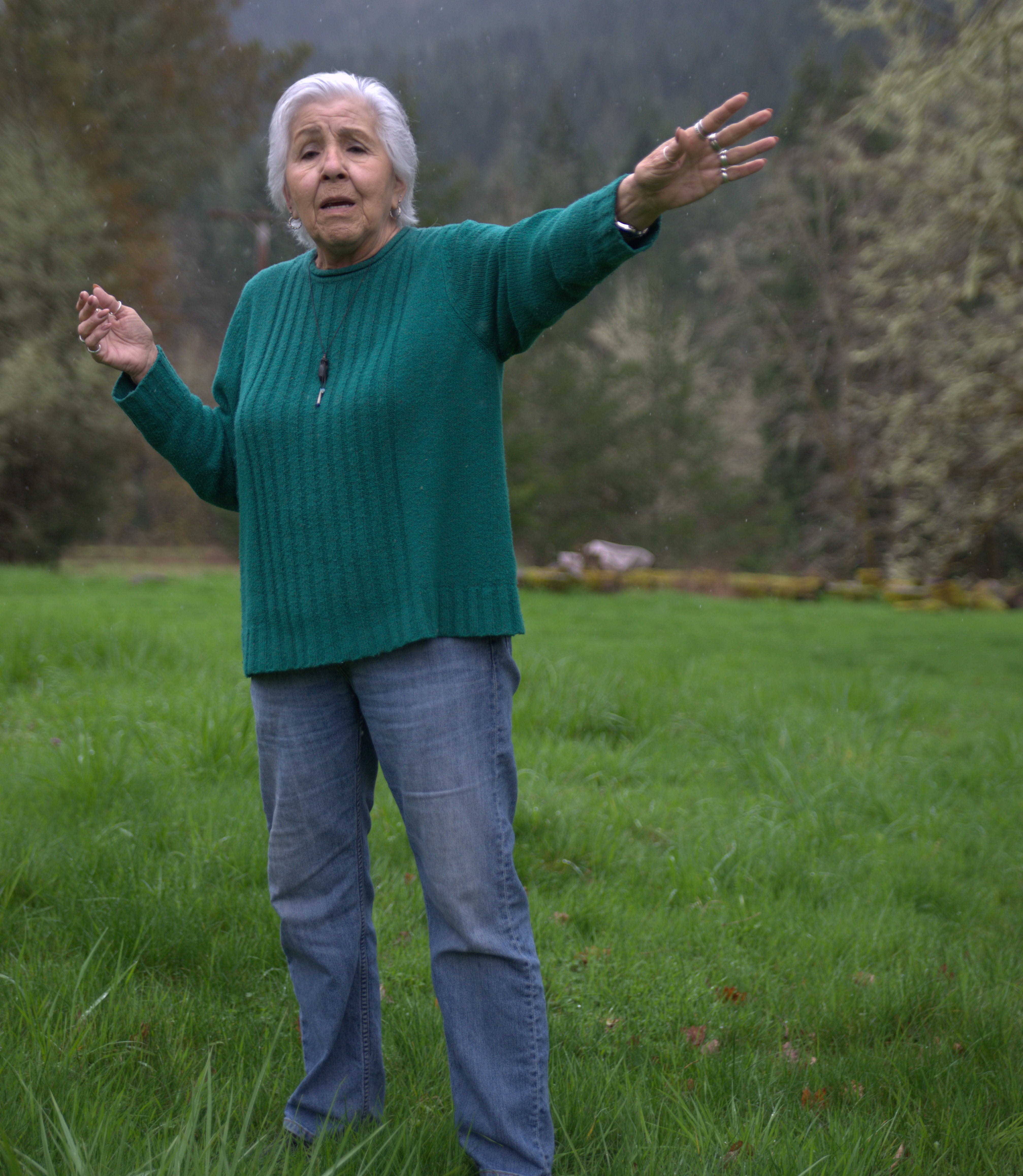Esther Stutzman telling a story in a field.