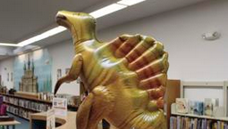 Inflatable dinosaur on a library shelf