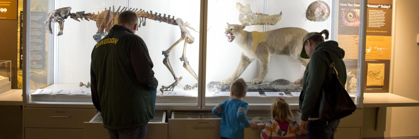 Family in front of collections case in Explore Oregon exhibit