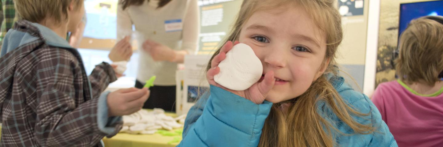 Child holding fossil craft