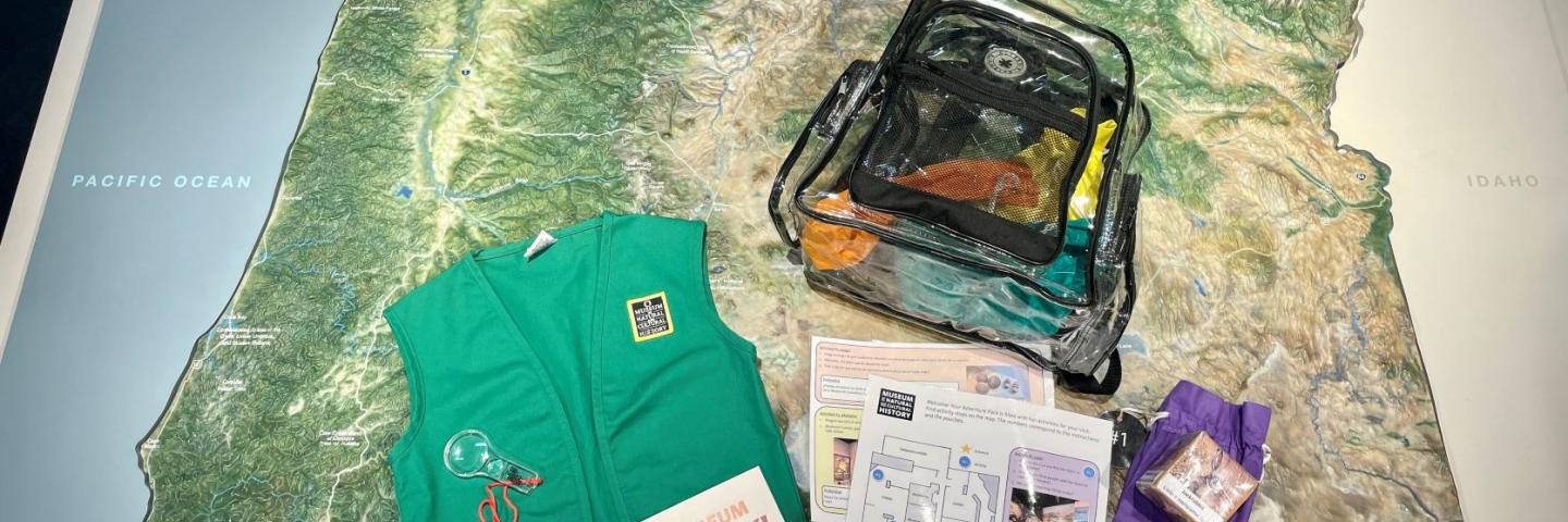 Clear backpack, green vest and activities sitting on a map of Oregon.