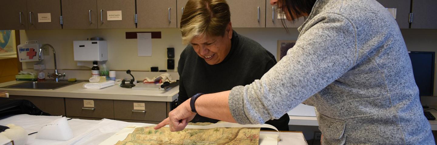 Mexican historian Lidia Gómez García examines a Latin American mapa with UO researcher Stephanie Wood. 