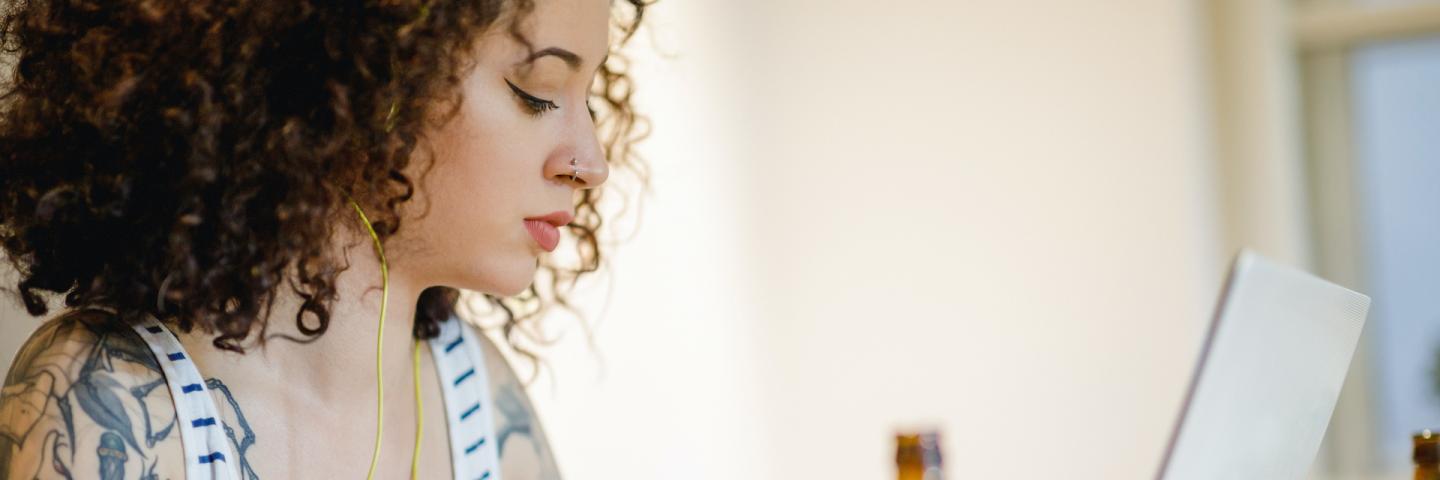 Woman at laptop enjoying an adult beverage