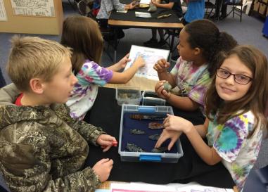 Students looking at artifacts during an outreach program
