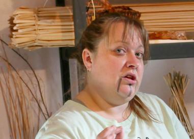 blonde haired woman in a light green t-shirt. There is a woven basket behind her.