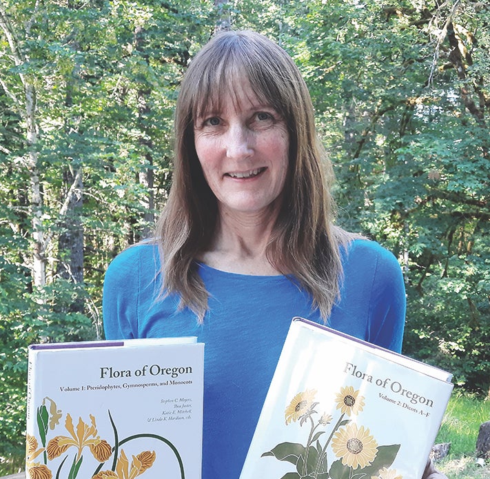 Linda Hardison holds two volumes of Flora of Oregon