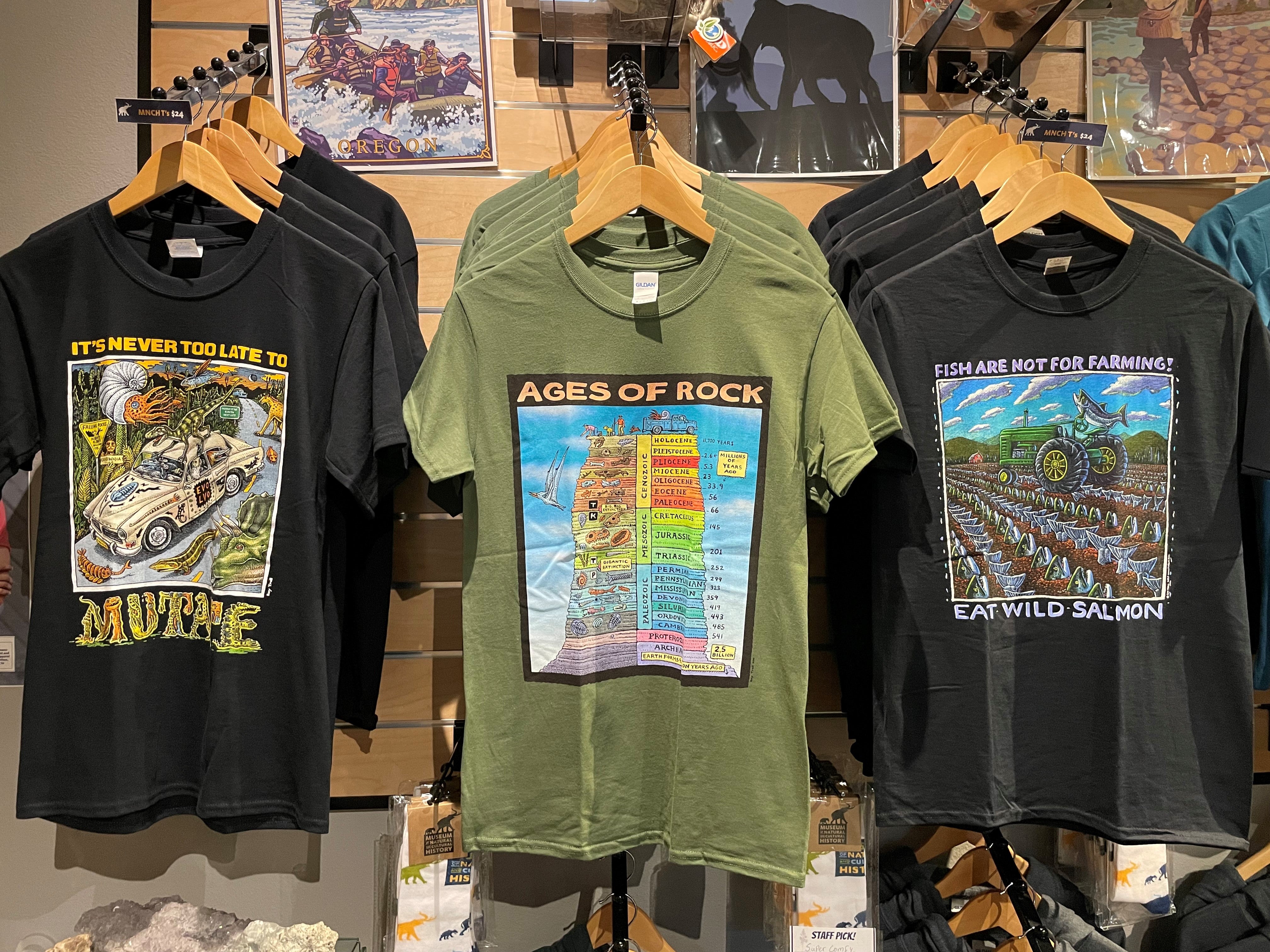 Three t-shirts in black and green with geology artwork on them.