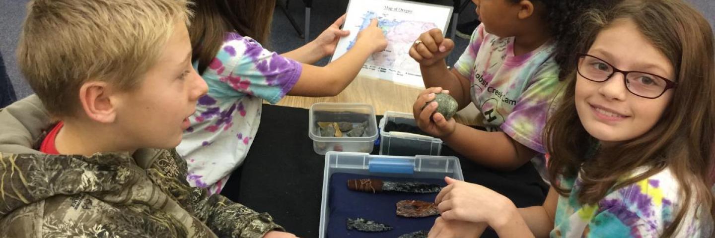 Students looking at artifacts during an outreach program